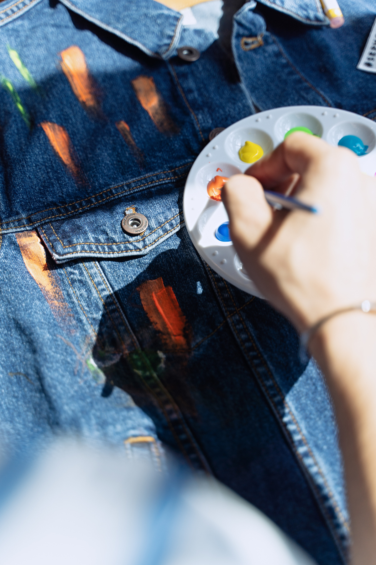 A Person Painting a Denim Jacket