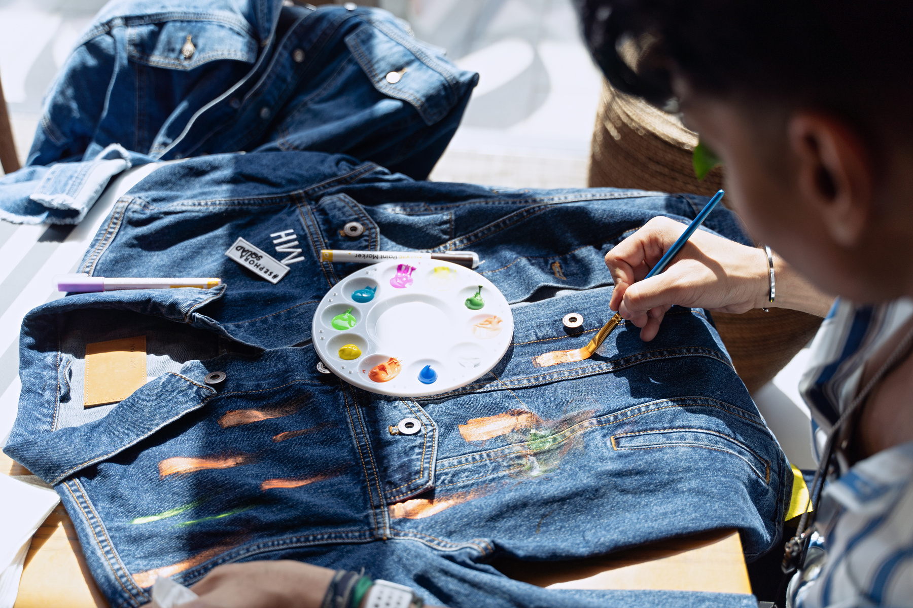 Person Painting a Denim Jacket